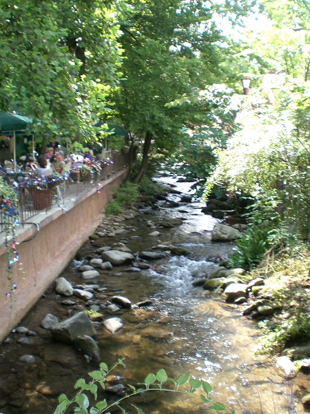 left: outdoor seating at a restaurant; middle: rocky stream; right and background: green trees